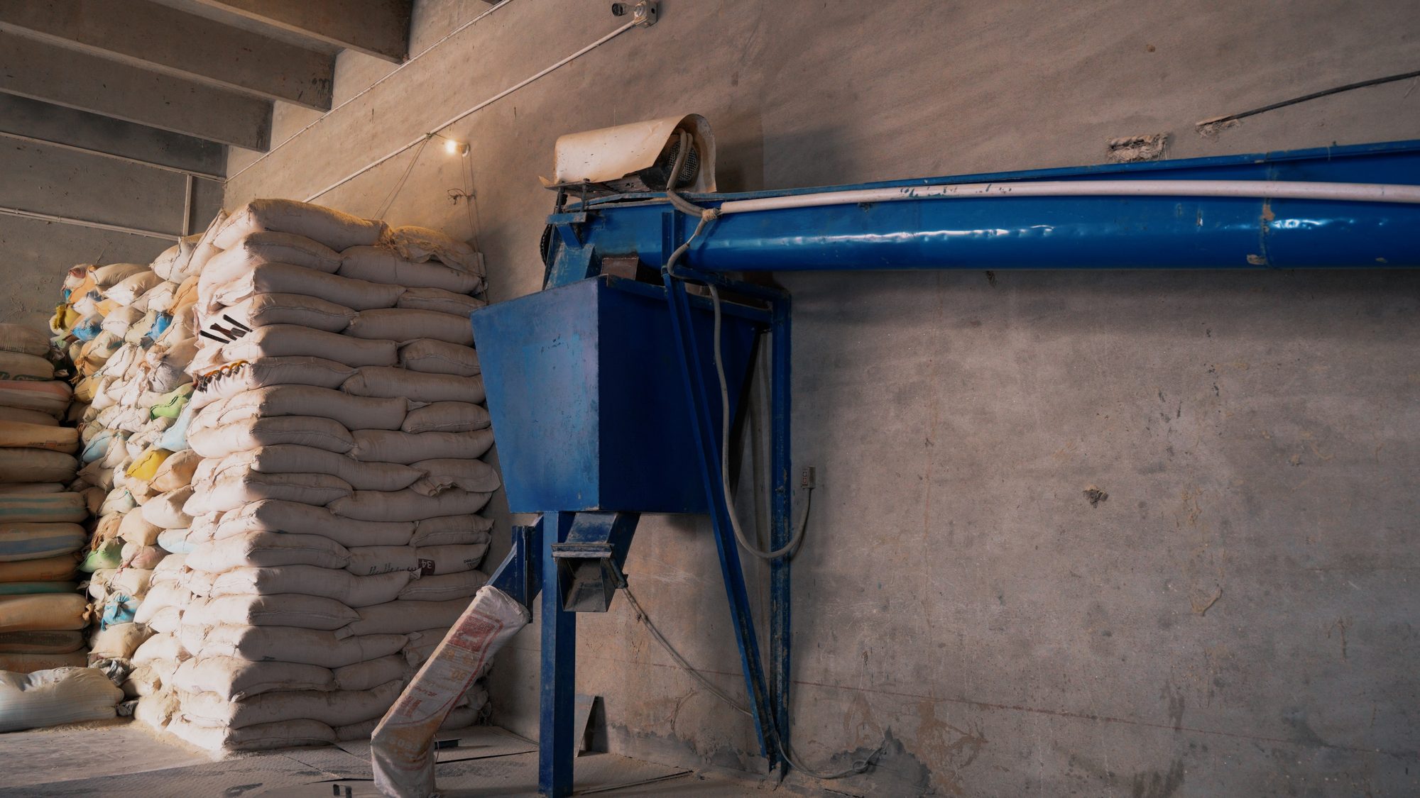 Stacked feed sacks beside the feed mixing equipment